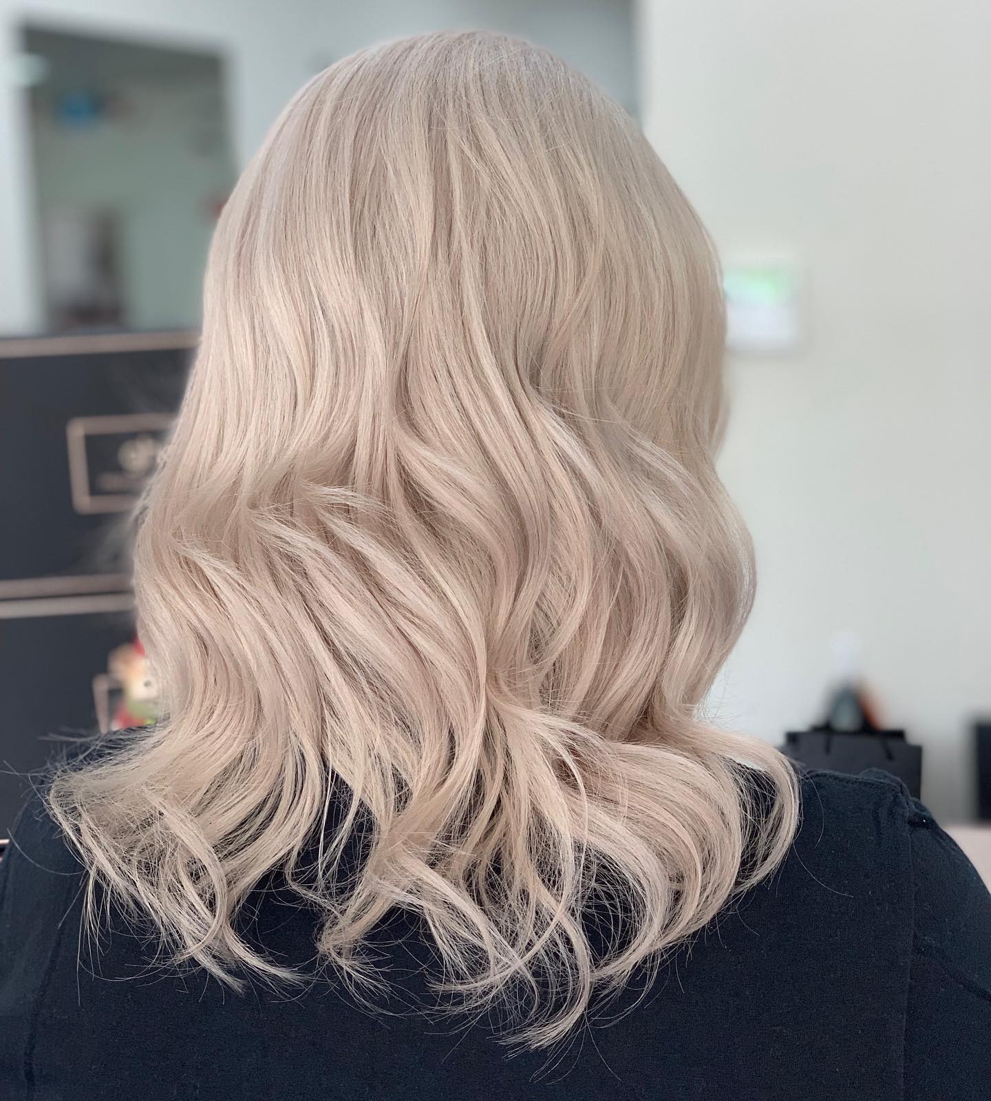 An icy champagne-blonde wavy lob coloured at Chisholm Hair Works