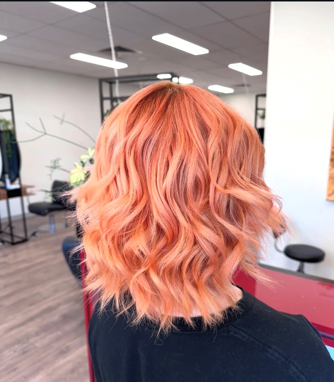 A peach-toned wavy bob colour and cut by Chisholm Hair Works